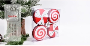 Detail of four red and white glitter candy ornaments in a clear box for Christmas