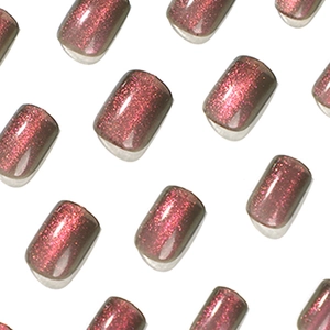 Short cat-eye press-on nails with pink glitter finish displayed on a white background