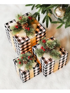 Close-up of black and white checkered Christmas gift boxes with pine cones and LED lights