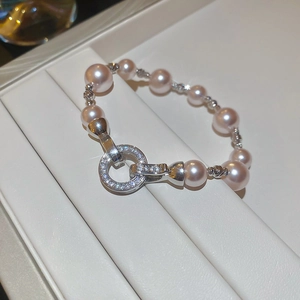 Vue macro de perles roses et fermoir argenté avec oxydes de zirconium sur plateau
