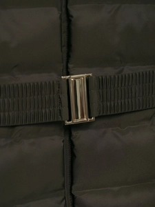 Detail shot of the black quilted jacket featuring a polished metallic waist belt buckle