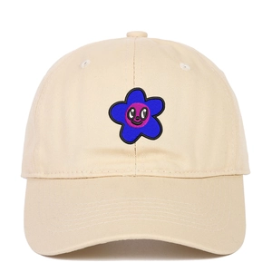 Détail de broderie de fleur avec smiley sur le devant d'une casquette en coton beige