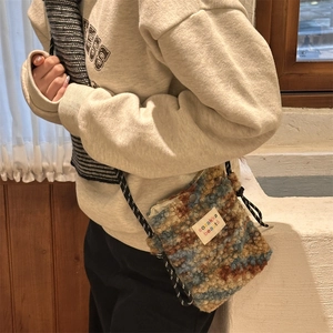 Detail of multi-color plush crossbody bag showing the soft texture and logo patch