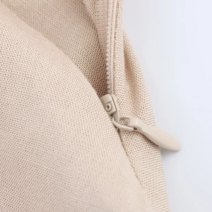 Detailed view of invisible zipper on beige knitted midi dress showing high quality texture