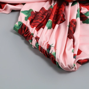Détail du tissu en satin rose avec imprimé rose montrant les coutures froncées élastiques