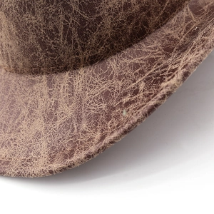 Macro shot of the vintage cracked texture and distressed brown finish on the jazz hat