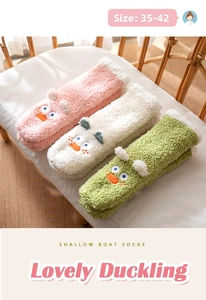 Detailed view of plush coral fleece slipper socks with cute cartoon duck embroidery