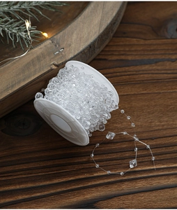Close-up of transparent acrylic bead garland on roll for Christmas tree decoration