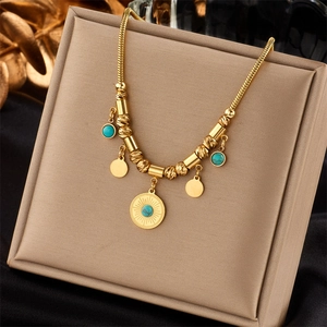 Detail of gold snake chain necklace featuring sun texture pendant and blue stone accents