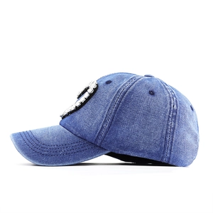 Macro view of blue distressed denim baseball cap with sparkling rhinestone letter ornament