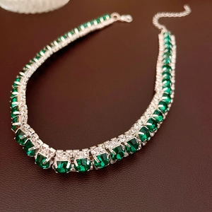Detailed close-up of emerald green square crystals on silver-tone necklace jewelry set