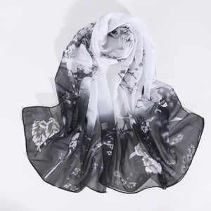 Detail of magpie and floral print on lightweight chiffon scarf with elegant draping