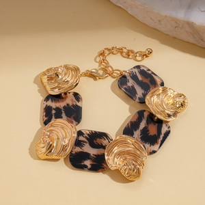 Detail of leopard print resin bracelet with gold-toned textured metal links and clasp