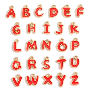 Macro view of 26 red enamel and gold-plated alloy letter pendants arranged in a grid