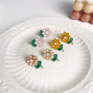 Nahaufnahme von französischen Blumenohrringen mit bunten Perlen und Kristallen auf Keramik