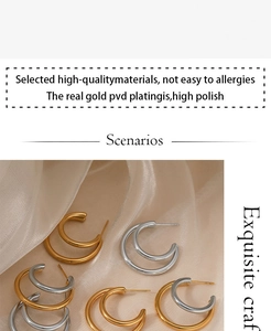 Close-up of gold and silver double-layered C-shaped earrings on soft silk fabric