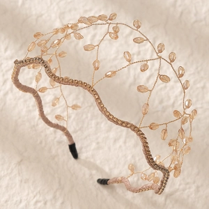 Macro detail of hand-woven mesh headband with champagne crystals and pink ribbon wrap