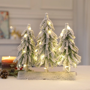 Set of 3 mini snowy Christmas trees with warm LED lights on a decorative winter base