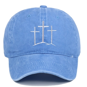 Macro detail of sky blue washed cotton cap with vintage distressed brim and cross embroidery