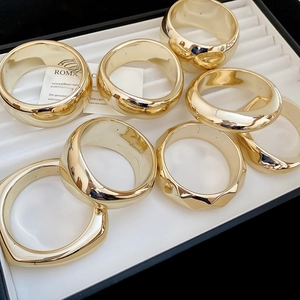 Détail de gros bracelets géométriques en acrylique doré avec fini métallisé en boîte