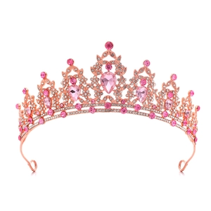 Macro shot of rose gold princess crown with pink crystal drops and intricate rhinestone detail