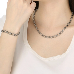 Close-up of model wearing adjustable stainless steel oval link chain necklace and bracelet set