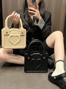 Detailed view of heart-embossed EVA tote bags in beige and black with round handles