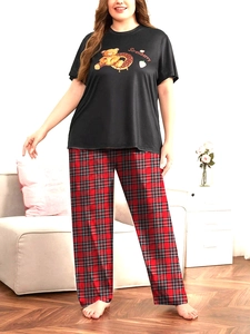 Dettaglio del pigiama taglie forti con t-shirt fragola e pantaloni lunghi a quadri