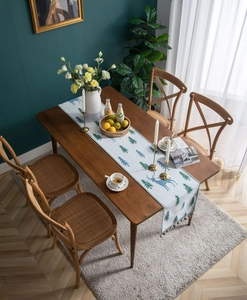 Detail of chenille table runner with deer and pine patterns on a wooden dining table
