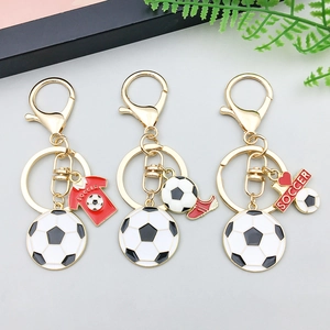 Dettaglio dei ciondoli da calcio in smalto colorato con portachiavi dorati per DIY