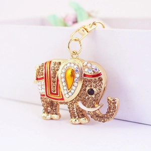 Gros plan du porte-clés éléphant avec strass marron et détails en émail rouge