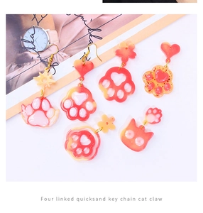 Cat paw resin earrings and pendants with glitter quicksand effect on pink background
