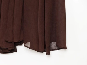 Detailed close-up of dark brown translucent chiffon fabric with delicate vertical pleats