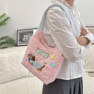 Detailed view of pink quilted tote bag with puppy embroidery and colorful buttons