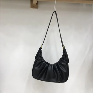 Detail view of the elegant black ruched crescent bag featuring fine gold hardware details