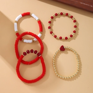 Detailed view of bohemian clay disc bracelets with heart charm and gold beads