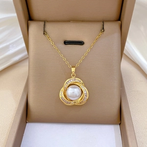 Macro view of gold titanium bird nest pendant with white pearl and micro diamonds