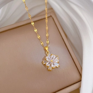 Macro shot of gold floral necklace set with micro-pave zircons on a leather box