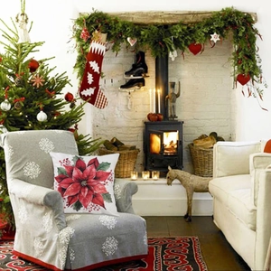 Detailed view of Christmas pillowcase with red poinsettia print on a grey armchair