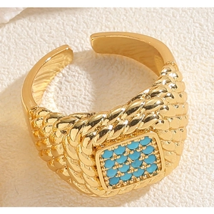 Detailed close-up of a gold braided band ring featuring a square turquoise stone inlay