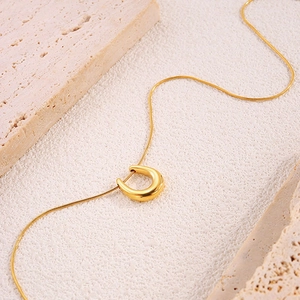 Close-up of 18k gold plated stainless steel U-shaped pendant on a snake chain necklace