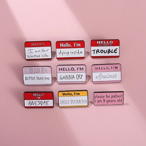 Macro detail of nine colorful enamel pins with motivational quotes in a grid layout