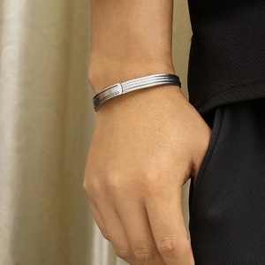 Close-up of a silver four-layer wire stainless steel open bangle on a male wrist