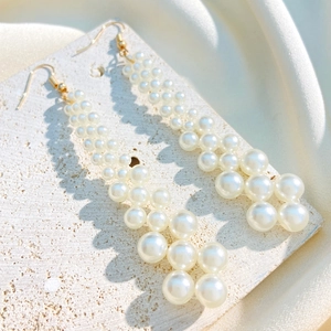 Elegant multi-layered pearl tassel drop earrings with gold hooks on marble background