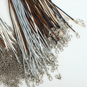 Close-up of colorful waxed cord necklaces and silver lobster clasps with metal extension chains
