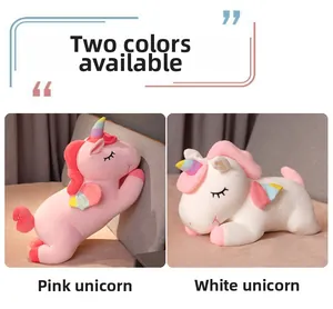 Close-up of cute pink and white plush unicorns with rainbow horns in a sleeping pose