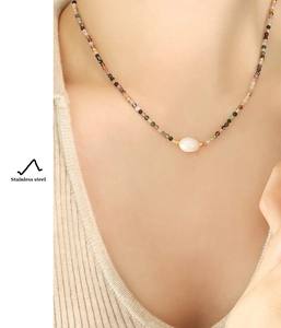 On-model shot of stainless steel necklace with colorful beads and natural pearl detail