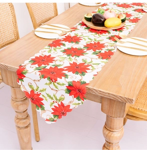 Detailed Christmas table runner with red poinsettia print and wavy scalloped edges