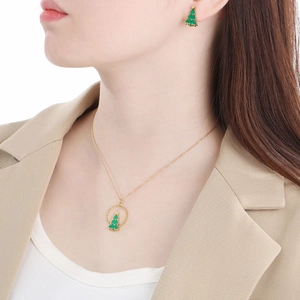 Goldenes Weihnachtsbaum-Schmuckset mit grüner Emaille-Kette und Ohrringen am Modell