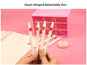 Close-up of white retractable heart-shaped gel pens with red charms on a pink desk